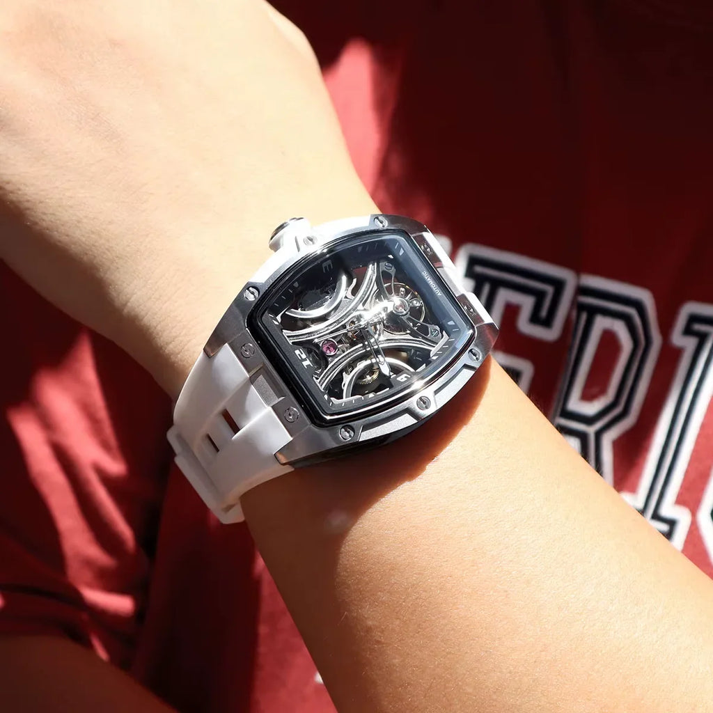 Modern motorsport-inspired skeleton watch with tonneau case and white strap on wrist