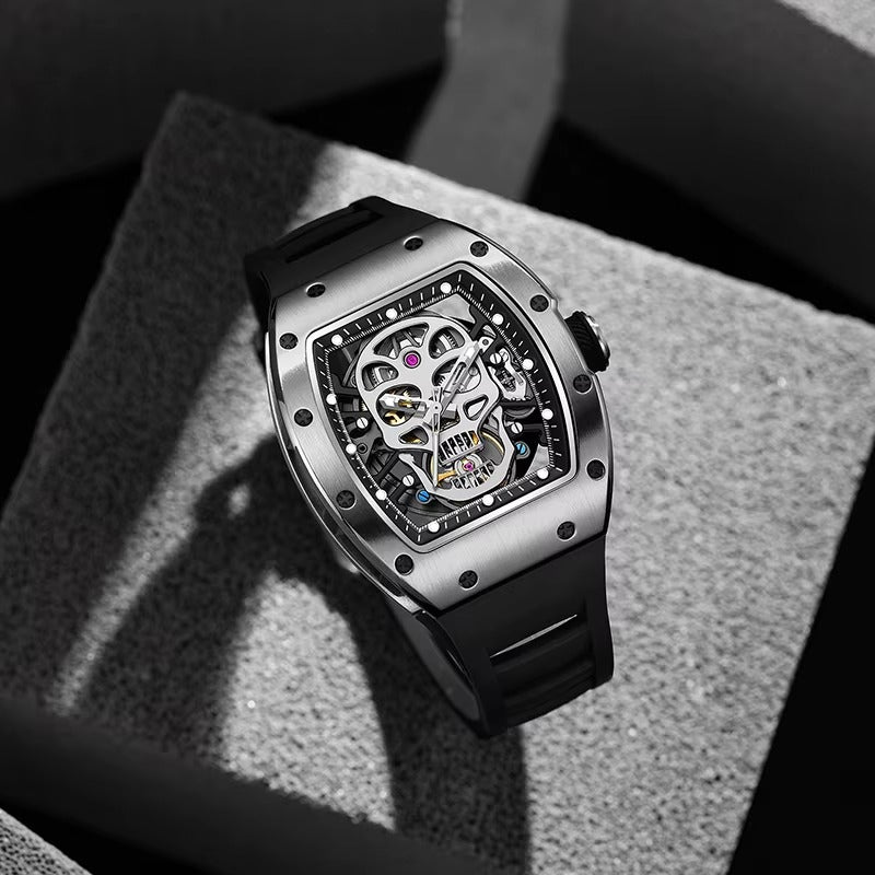 Skeleton dial luxury sport watch with skull motif, tonneau case, and black rubber strap