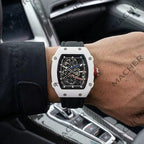 Luxury skeleton watch with white case, black strap, red crown, worn in car — motorsport-inspired design