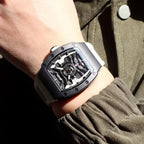 Motorsport-inspired skeleton dial watch with tonneau case and white strap on wrist