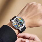 Close-up of a luxury skeleton watch with a colorful dial and black strap on a person's wrist.