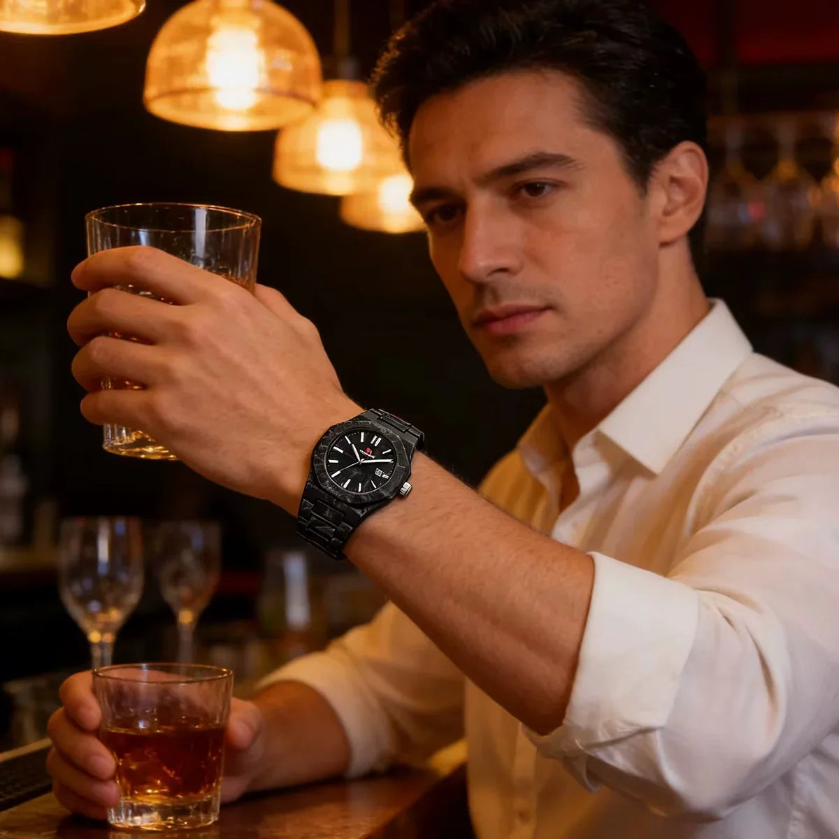 Man in a bar wearing a bold black sport-luxury watch with racing-inspired design