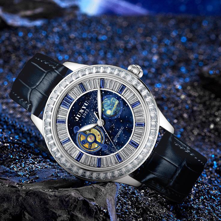 Automatic luxury watch with celestial blue dial, planet motif, and crystal accents on black leather strap