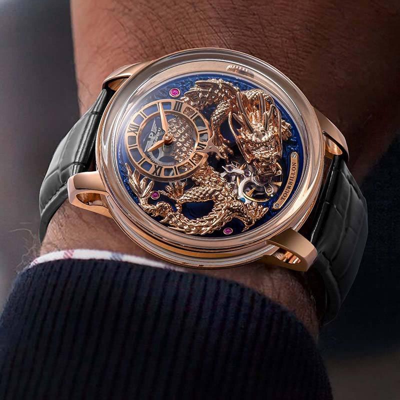 Luxury dragon motif tourbillon watch with gold case and black leather strap on wrist