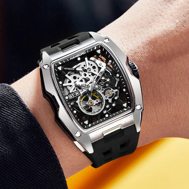 Racing-inspired skeleton dial watch with black rubber strap, silver case, and sporty design