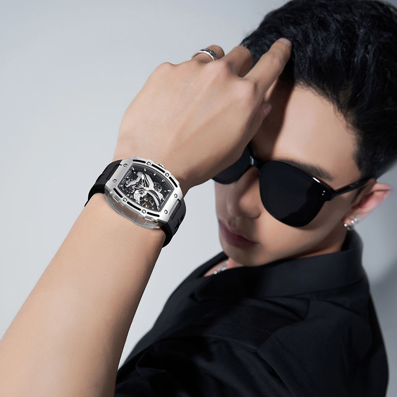 Stylish man wearing motorsport-inspired luxury watch with bold square case and black strap