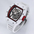 White racing-inspired skeleton watch with tonneau case, red crown, and exposed movement.