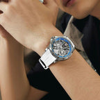 Luxury racing-inspired skeleton watch with white strap and blue bezel on wrist