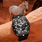 Luxury motorsport-inspired skeleton watch with black carbon fiber case on wrist, horses in background