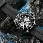 Motorsport-inspired sport-luxury chronograph watch with black bezel, bold dial, and rubber strap on a stylish textured surface