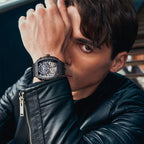 Man in leather jacket wearing sporty skeleton dial luxury watch with motorsport-inspired design