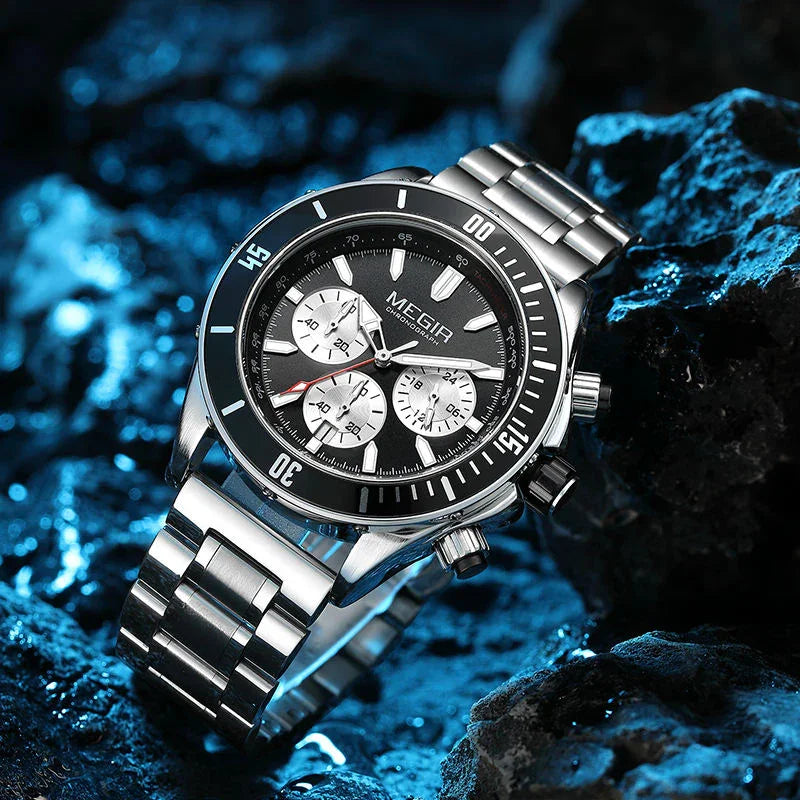 Stainless steel chronograph watch with bold motorsport-inspired design on textured rocks