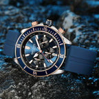 Blue chronograph sport-luxury racing watch with bold dial, rose gold accents, rubber strap