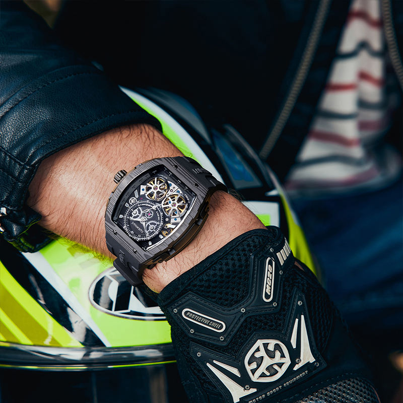 Motorsport-inspired luxury skeleton watch with black case on rider’s wrist, racing gloves and helmet visible