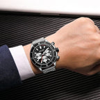 Luxury motorsport-inspired chronograph watch with black dial and metal band on wrist
