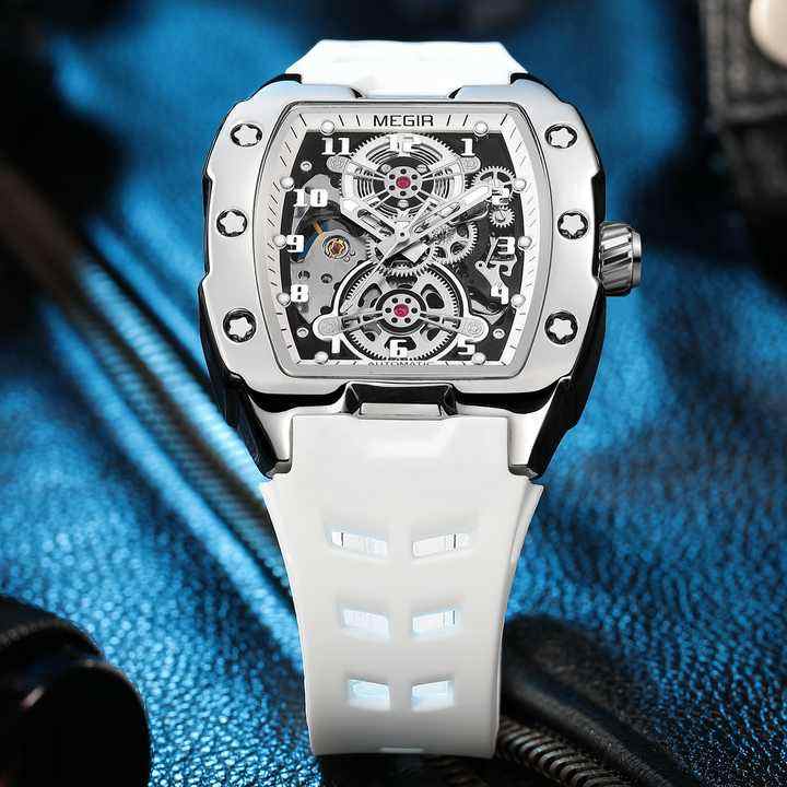 Motorsport-inspired skeleton watch with square case, visible gears, and white strap on blue fabric
