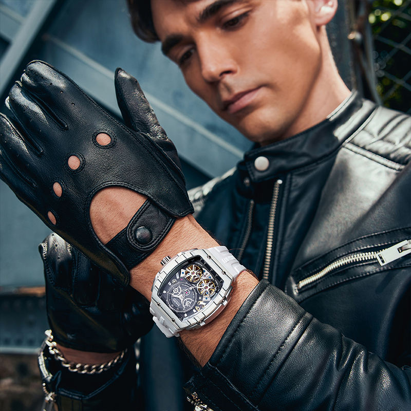 Luxury motorsport-inspired skeleton watch with white band on man's wrist, leather gloves, leather jacket