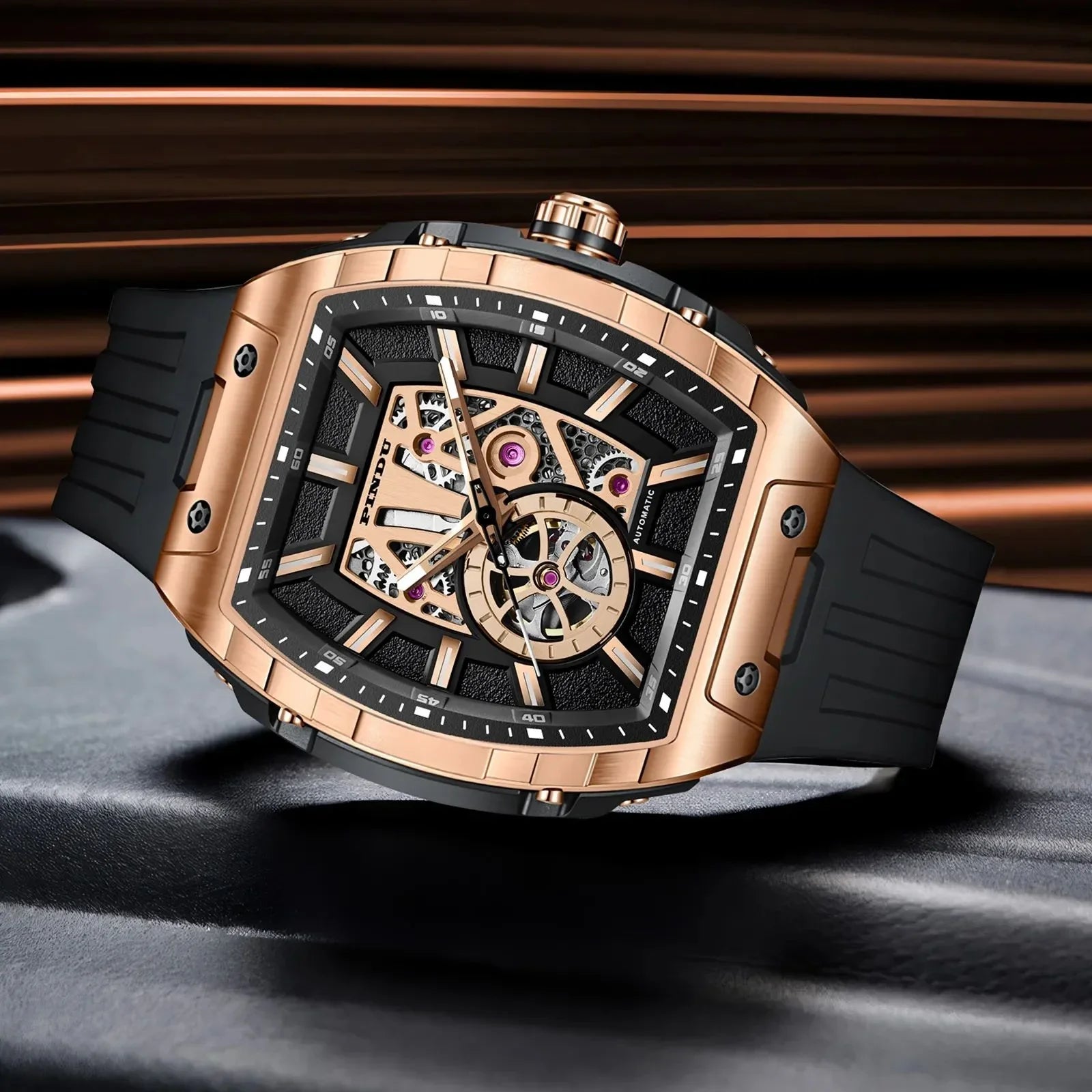 Luxury motorsport-inspired rose gold tonneau watch with skeleton dial and black rubber strap