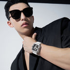 Man in black suit wearing bold white luxury motorsport-inspired skeleton watch