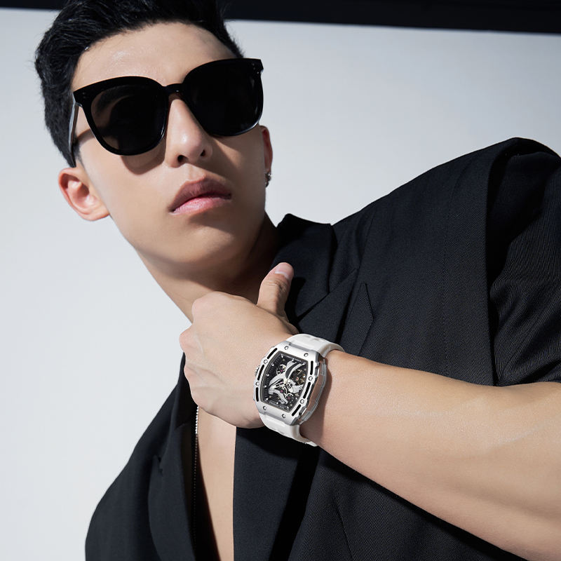Man in black suit wearing bold white luxury motorsport-inspired skeleton watch