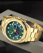 Gold motorsport-inspired watch with green and blue chronograph dial, solid bracelet, luxury sporty style